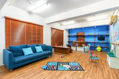 a living room with a blue couch and a table at Naiyang Villa in Nai Yang Beach