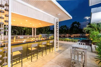 a patio with a bar and a swimming pool at Naiyang Villa in Nai Yang Beach