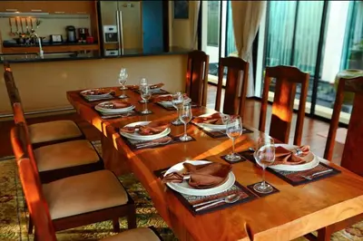 a wooden table with plates and wine glasses on it at Kamala Private Bliss Retreat 4 Bedrooms Villa in Kamala Beach