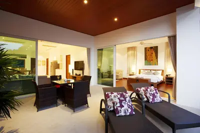 a living room with a dining table and a bedroom at Sea View Pool Villa Grand Kamala Falls in Kamala Beach