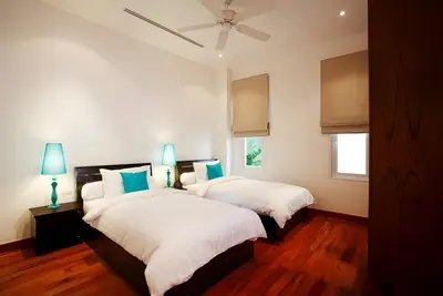 two beds in a bedroom with two lamps and a window at Sea View Pool Villa Grand Kamala Falls in Kamala Beach