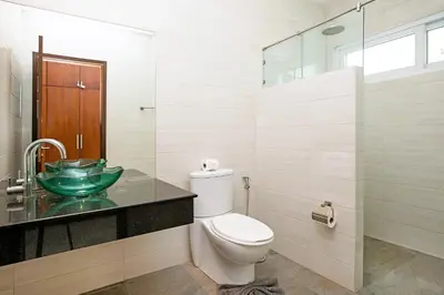 a bathroom with a toilet and a glass sink at 2 Bedroom Villa Janine with Private Pool and Rooftop terrace in Kamala Beach