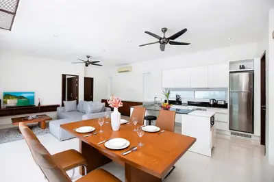 a kitchen and living room with a wooden table and a dining room at 2 Bedroom Villa Janine with Private Pool and Rooftop terrace in Kamala Beach