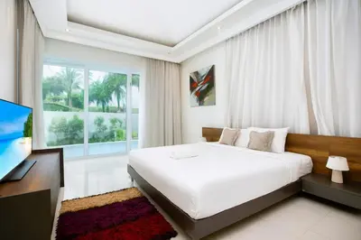 a white bedroom with a large bed and a television at 2 Bedroom Villa Janine with Private Pool and Rooftop terrace in Kamala Beach