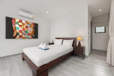 a bedroom with a bed and a painting on the wall at Villa Mauri – Modern 3BR Villa with Private Pool in Kata Beach