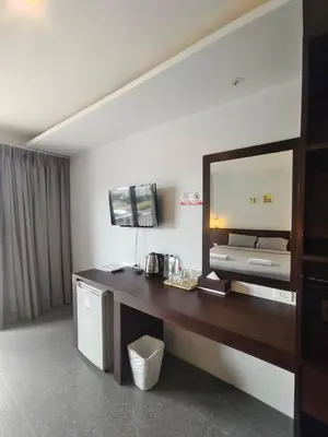 a hotel room with a desk and a mirror at Doze Bangla in Patong Beach