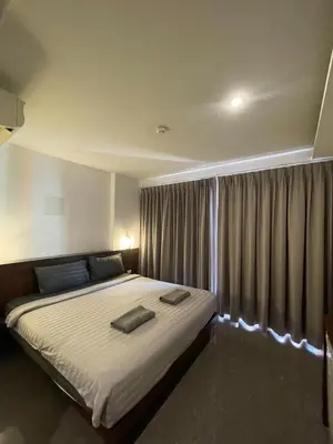 a bedroom with a large bed with a window at Doze Bangla in Patong Beach