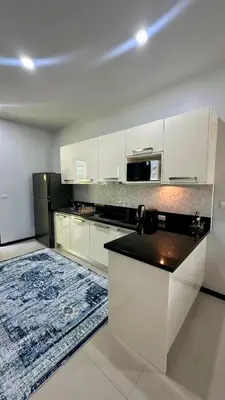a kitchen with white cabinets and a black counter top at Cozy villa - perfect place to stay in Phuket in Ban Saiyuan (1)