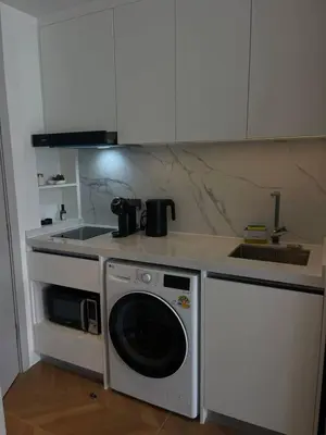 a kitchen with a washing machine and a sink at Kora Beach Studio in Layan Beach