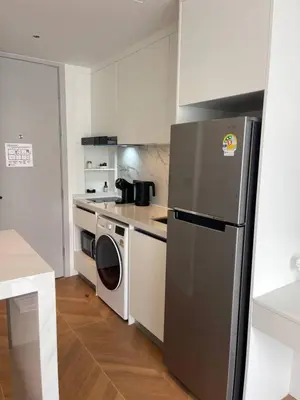 a kitchen with a refrigerator and a washing machine at Kora Beach Studio in Layan Beach