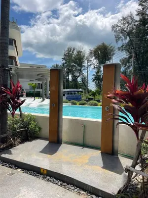 a door leading to a swimming pool with a building at Kora Beach Studio in Layan Beach