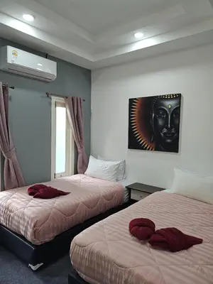 a room with two beds and a painting of a mask at Beautiful New 3 Bed 3 Bathroom Villa 400m to Bang Tao Beach Sleeps 9 in Ban Thalat Choeng Thale