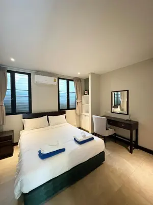 a bedroom with a bed with two blue towels on it at Bukitier Luxury Pool Villa Bangtao in Bang Tao Beach