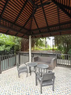 a patio with tables and chairs and a wooden roof at Bukitier Luxury Pool Villa Bangtao in Bang Tao Beach