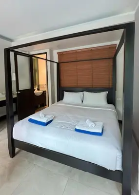 a bedroom with a large bed with two towels on it at Bukitier Luxury Pool Villa Bangtao in Bang Tao Beach