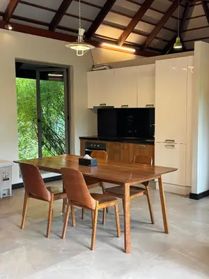 a wooden table in a kitchen with chairs and a table at Bukitier Luxury Pool Villa Bangtao in Bang Tao Beach
