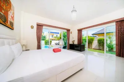 a bedroom with a large white bed and sliding glass doors at Mediteranean style 3 BR Pool Villa Platinum with garden in Rawai Beach