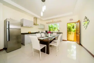 a kitchen with a table and chairs and a refrigerator at Mediteranean style 3 BR Pool Villa Platinum with garden in Rawai Beach