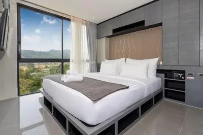 a bedroom with a large bed with a large window at Tropics Kamala CTG P615 - Corner 1 BR Apt Mountain view in Kamala Beach