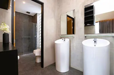 a bathroom with two white sinks and a mirror at Nature-Inspired 2BR Duplex P12 with pool and gym in Kamala Beach