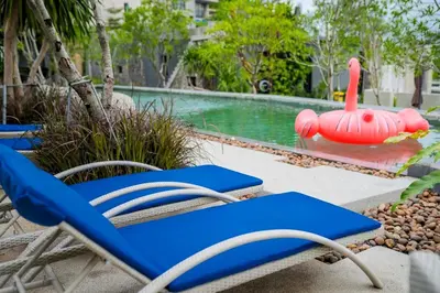 a pool with a blue chair and a inflatable swan at Nature-Inspired 2BR Duplex P12 with pool and gym in Kamala Beach
