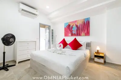a bedroom with a white bed with red pillows at 8-minute walk to the beach - 3 bedrooms 3 baths in Patong Beach