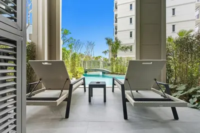 a patio with two chairs and a swimming pool at The Title Legendary Bangtao by Beringela in Bang Tao Beach