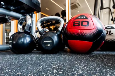 a soccer ball and dumbbells on a gym floor at The Title Legendary Bangtao by Beringela in Bang Tao Beach