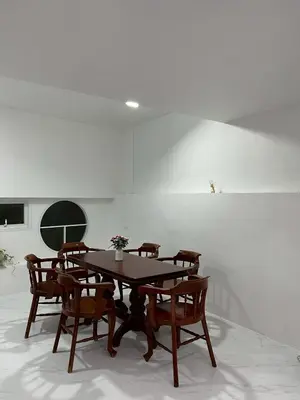 a wooden table and chairs in a white room at Nur Nur Residence and villa in Surin Beach