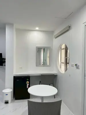 a white room with a table and a mirror at Nur Nur Residence and villa in Surin Beach