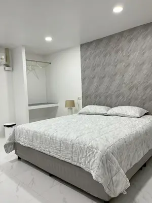 a bedroom with a large bed with a gray headboard at Nur Nur Residence and villa in Surin Beach