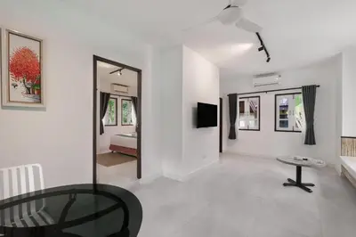a living room with a glass table and a bedroom at Palm Village in Rawai Beach