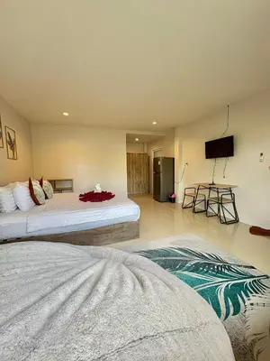 a bedroom with two beds and a flat screen tv at Cozy 1-Bedroom apartment in Surin Beach