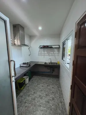 a small kitchen with a sink and a counter at Cozy 1-Bedroom apartment in Surin Beach