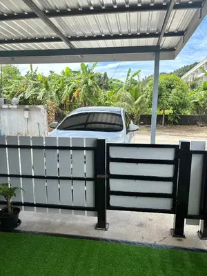 a car parked behind a fence with a car behind it at Cozy 1-Bedroom apartment in Surin Beach