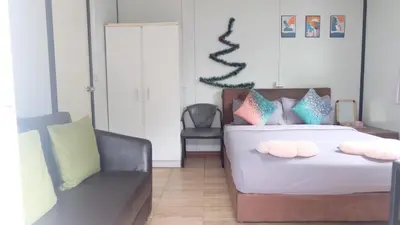 a bedroom with a bed with two pillows and a couch at Wings Alley Phuket in Phuket
