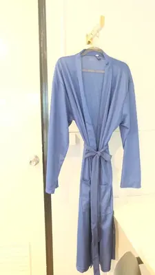 a blue robe is hanging on a rack at Wings Alley Phuket in Phuket