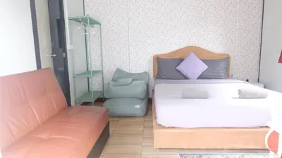 a bedroom with a bed and a couch at Wings Alley Phuket in Phuket