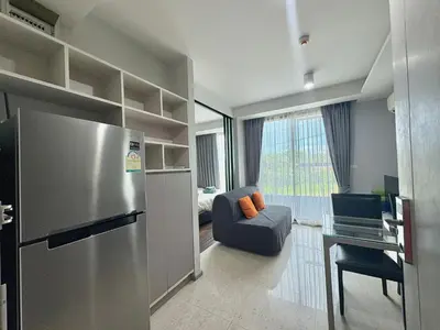 a kitchen with a stainless steel refrigerator and a living room at 1 Bedroom l 6th Avenue l Surin beach in Surin Beach