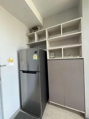 an empty kitchen with a refrigerator and shelves at 1 Bedroom l 6th Avenue l Surin beach in Surin Beach
