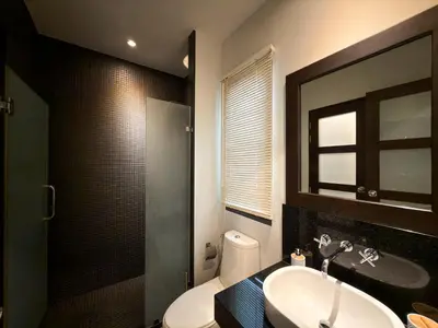 a bathroom with a sink and a toilet and a mirror at Villa 2BD Nai Harn Beach by Mill in Ban Saiyuan (1)