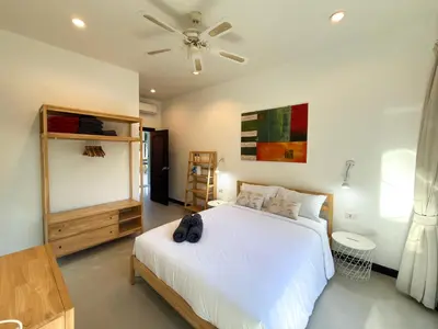 a bedroom with a white bed and a ceiling fan at Nai Harn Family Pool Villa 3 BDR by Mill in Ban Saiyuan (1)