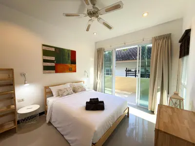 a bedroom with a bed and a large window at Nai Harn Family Pool Villa 3 BDR by Mill in Ban Saiyuan (1)