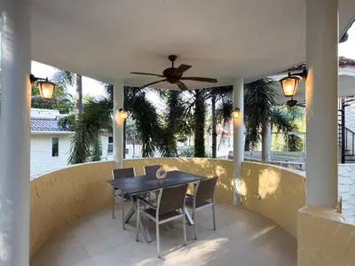 a patio with a table and chairs and a ceiling fan at Nai Harn Family Pool Villa 3 BDR by Mill in Ban Saiyuan (1)
