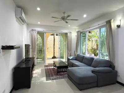a living room with a blue couch and a table at Nai Harn Family Pool Villa 3 BDR by Mill in Ban Saiyuan (1)