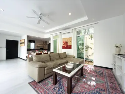 a living room with a couch and a table at Nai Harn Family Pool Villa 4 bdr in Ban Saiyuan (1)