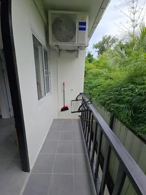 a balcony with a fan on the side of a house at The Simple Place - King in Klong Muang Beach