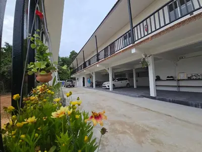 a building with a bunch of flowers in front of it at The Simple Place - King in Klong Muang Beach
