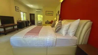 a bedroom with a large white bed with a red wall at The Simple Place - King in Klong Muang Beach