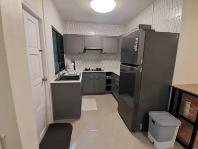 a kitchen with a black refrigerator and a sink at Kata Beach Townhouse 3 in Kata Beach